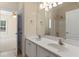 Bright bathroom featuring double sinks, white cabinets, a large mirror and access to the bedroom at 240 Huiet Dr, Mcdonough, GA 30252