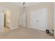 Carpeted bedroom with double closets and an open door to the Primary bath at 240 Huiet Dr, Mcdonough, GA 30252