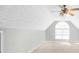 Spacious attic featuring plush carpeting, vaulted ceilings, and a large arched window at 950 Besse Way, Locust Grove, GA 30248