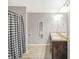 Bathroom featuring a double sink vanity, wood-look floors, and a stylish patterned shower curtain at 950 Besse Way, Locust Grove, GA 30248