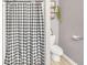 Bathroom featuring a stylish patterned shower curtain, toilet, and a decorative shelf at 950 Besse Way, Locust Grove, GA 30248