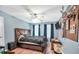 Cozy bedroom featuring wood laminate flooring, ceiling fan, and cool-toned walls at 950 Besse Way, Locust Grove, GA 30248