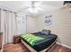 Cozy bedroom with wood-paneled accent wall, ceiling fan, hardwood floor, and rustic-style furnishings at 950 Besse Way, Locust Grove, GA 30248