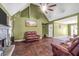 Spacious living room with vaulted ceilings, a cozy fireplace, and comfortable leather seating at 950 Besse Way, Locust Grove, GA 30248