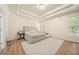 Relaxing bedroom featuring a plush bed, tray ceiling, and ample natural light from large windows at 1867 Willoughby Dr, Buford, GA 30519
