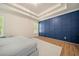 Bright bedroom with tray ceiling, wood floors, and a stylish, modern blue accent wall at 1867 Willoughby Dr, Buford, GA 30519