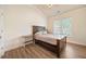 Bright bedroom with wood floors, nice bed, and natural light from the large window at 1867 Willoughby Dr, Buford, GA 30519