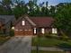 Beautiful brick home featuring a well-manicured lawn and a two-car garage at dusk at 1867 Willoughby Dr, Buford, GA 30519