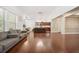 Bright, open-concept living space with hardwood flooring, large windows and view into the kitchen area at 1867 Willoughby Dr, Buford, GA 30519