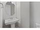 A well-lit half-bathroom features a pedestal sink and oval mirror at 2122 Pembroke Dr, Brookhaven, GA 30319