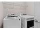 Functional laundry room with modern washer and dryer units, complemented by overhead shelving at 2122 Pembroke Dr, Brookhaven, GA 30319