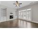Bright living room featuring a fireplace, hardwood floors, and three doors leading to a balcony for relaxed living at 2122 Pembroke Dr, Brookhaven, GA 30319