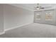 Spacious carpeted primary bedroom featuring a tray ceiling, ceiling fan, and two bright, window views at 2122 Pembroke Dr, Brookhaven, GA 30319