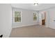 Bright bedroom with neutral walls, two windows, and a doorway to a bathroom at 4720 Cooling Water Sw Cir, Powder Springs, GA 30127