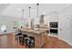 Open kitchen with island seating, modern appliances and hardwood floors at 4720 Cooling Water Sw Cir, Powder Springs, GA 30127