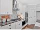Bright kitchen with stainless steel vent hood, double ovens and sleek countertops at 4720 Cooling Water Sw Cir, Powder Springs, GA 30127