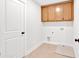 Bright laundry room with wood cabinets, tile floors, and access for a washing machine and dryer at 4720 Cooling Water Sw Cir, Powder Springs, GA 30127