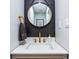 Modern bathroom with a round mirror, brass fixtures, and a sleek vanity at 5925 Old Bill Cook Rd, South Fulton, GA 30349