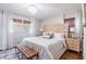 Bedroom boasts a tufted headboard, elegant chandelier and natural light through bright windows at 5925 Old Bill Cook Rd, South Fulton, GA 30349