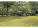 Charming gray home is surrounded by lush greenery and mature trees at 633 Iris Rd, Pine Lake, GA 30072