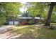 Charming gray home with a two-car garage, inviting red front deck and mature trees at 633 Iris Rd, Pine Lake, GA 30072
