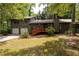 Charming gray home featuring a two-car garage and a welcoming red deck entrance at 633 Iris Rd, Pine Lake, GA 30072