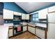 Kitchen featuring white appliances, white cabinetry, and laminate countertop at 633 Iris Rd, Pine Lake, GA 30072