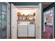 This laundry room includes a modern washer and dryer and storage shelves at 633 Iris Rd, Pine Lake, GA 30072