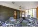 Enclosed porch featuring a glass table and surrounding cushioned furniture and ceiling fan at 633 Iris Rd, Pine Lake, GA 30072
