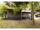 Back exterior featuring a screened porch and upper level deck surrounded by leafy trees at 633 Iris Rd, Pine Lake, GA 30072