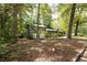View of the side of the home, showing the wood exterior surrounded by mature trees at 633 Iris Rd, Pine Lake, GA 30072