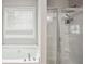 Bathroom features a soaking tub and walk-in shower with glass doors and chrome fixtures at 9744 Musket Ridge Cir, Jonesboro, GA 30238