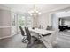 Elegant dining room with a modern chandelier, bay window, and a dining table for six at 9744 Musket Ridge Cir, Jonesboro, GA 30238
