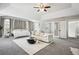 Expansive main bedroom with a seating area and plush furniture, large windows, and a ceiling fan at 9744 Musket Ridge Cir, Jonesboro, GA 30238