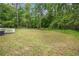Large grassy backyard featuring a wooden deck and mature trees at 1786 Richard Ne Rd, Conyers, GA 30012