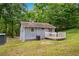 Rear exterior of cottage with wooden deck, grassy lawn and mature trees at 1786 Richard Ne Rd, Conyers, GA 30012