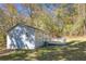 Back of charming cottage featuring a wooden deck, grassy lawn and mature trees at 1786 Richard Ne Rd, Conyers, GA 30012