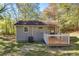 Back of cottage with wooden deck, air conditioning unit, grassy lawn and mature trees at 1786 Richard Ne Rd, Conyers, GA 30012