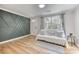 Comfortable living room with wood accent wall, hardwood floors, large windows, and neutral tones at 1786 Richard Ne Rd, Conyers, GA 30012