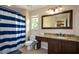 Bathroom features a large mirror, vanity with granite counters, blue and white shower curtain at 2002 Fairbrook Ln, Woodstock, GA 30189