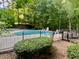 Community pool area surrounded by a black fence and lush green bushes at 2002 Fairbrook Ln, Woodstock, GA 30189