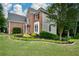 Side view of a brick home with mature trees and beautiful landscaping featuring a lush green lawn at 2002 Fairbrook Ln, Woodstock, GA 30189