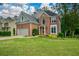 Charming brick home featuring a well-manicured lawn, attached two-car garage, and beautiful landscaping at 2002 Fairbrook Ln, Woodstock, GA 30189