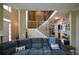 Comfortable living room featuring a large blue sofa and open staircase with iron railings at 2002 Fairbrook Ln, Woodstock, GA 30189