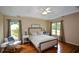 Bright main bedroom with hardwood floors, ceiling fan, and natural light at 2002 Fairbrook Ln, Woodstock, GA 30189