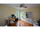 Bright home office features hardwood floors, a ceiling fan, and windows with backyard view at 2002 Fairbrook Ln, Woodstock, GA 30189