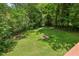 Sprawling backyard with lush lawn and fire pit surrounded by mature trees and greenery at 2381 Woodacres Ne Rd, Atlanta, GA 30345