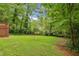 Expansive backyard with a fire pit, level lawn, and mature trees for shade and privacy at 2381 Woodacres Ne Rd, Atlanta, GA 30345