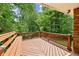Wooden deck featuring a built-in bench overlooking a private backyard and wooded area at 2381 Woodacres Ne Rd, Atlanta, GA 30345