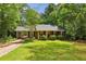 Quaint brick home with a lush green lawn and mature trees, complemented by a covered carport at 2381 Woodacres Rd, Atlanta, GA 30345